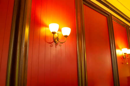 Lighting lamps on red walls highlighted by wooden framesの写真素材