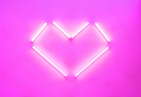 Neon lamps in the shape of a heart, angular shapes glowing on a pink background