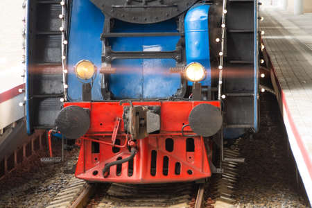 View of the lower red grille bumper of a locomotive on railsの写真素材