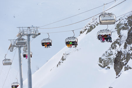 View of the ski resort - mountains, lifts, snow-capped peaks. Recreational skiers and snowboarders....