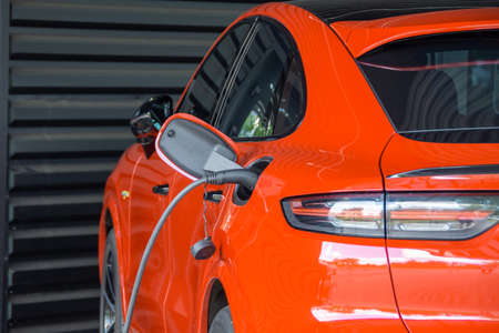 Socket plug with charging for red electric car, charging battery close up view. electric stationの写真素材
