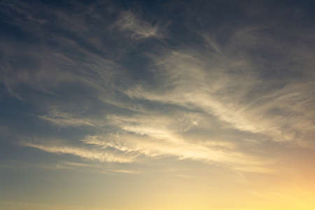 Background of cirrus clouds on the burning dawn in the sky after golden sunset