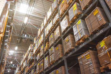 Retail warehouse full of shelves with goods in wooden crates, boxes and packages. Logistics, sorting and distribution for product delivery. Look up, lightの写真素材