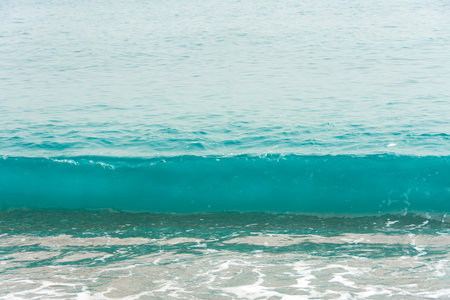 Sea waves in blue color with foam on the warm coast of the resort in the summerの写真素材