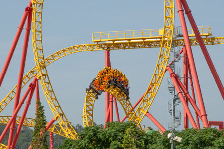 Amusement trolley makes circle loop turns rides in a spiral, red yellow roller coasterの写真素材