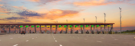 Panoramic vew entrance to the toll road, limited by the barrier. Cashless payment transponder, speed limit signs. Format banner header wide size, place sample textの写真素材