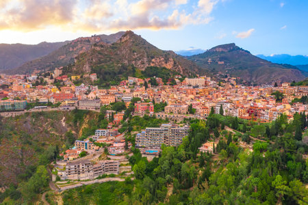 Town on the slopes of mountains and hills, evening citiscape aerial viewの写真素材