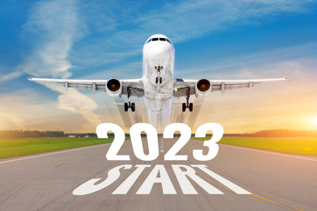 Inscription on the runway start 2023 surface of the airport road line rapidly taking off aircraft....