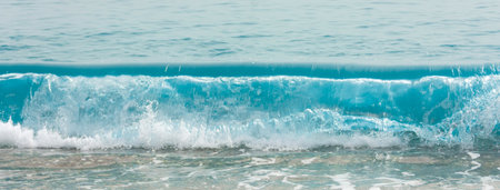 Sea waves in blue color with foam on the warm coast of the resort in the summer. Wide panoramic viewの写真素材
