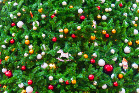 Texture background of branches of green decorated fragrant spruce toys, shiny balls, electric...