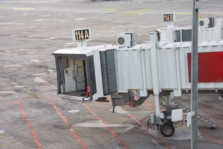 Teletrap at the airport terminal and a standing plane in the distanceの写真素材