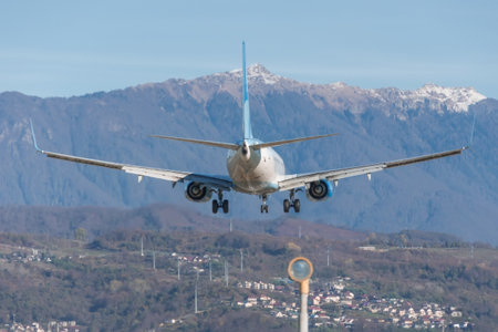 Passenger plane landed at the airfield in the mountains, in the distance a village on a slopeの写真素材