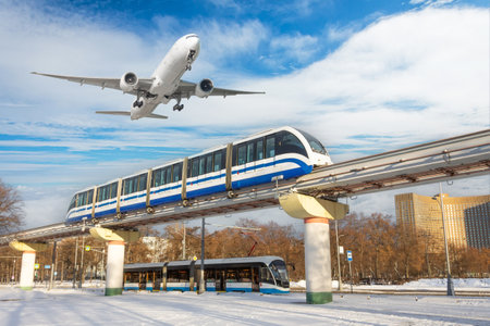 View railway track suburban electric monorail train rushing departure area airfield. Passenger plane jet flying sky, take off airport winter snow. Concept city modern infrastructure transport travelの素材 [FY310197029844]