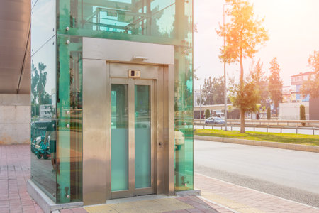Glass elevator on a pedestrian crossing across a highway