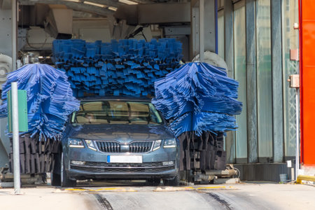 Automatic wash blue brush in action, grey car comes out ready cleanの写真素材