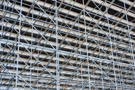 Metal pipe frame structure. Industrial construction from tubes raises upwards. Building process and joining elements view. Straight and inclined lines backdropの写真素材