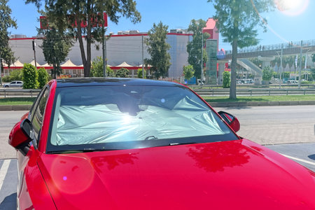 Protective reflective surface under the windshield of the passenger red car parked on a hot day, heated by the sun's rays inside the carの写真素材