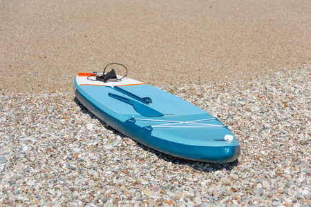 Lonely sup board on the beach lies on the sandの写真素材