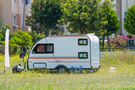 Mobile home trailer on wheels van parked in the street on the meadow of the city parkの写真素材