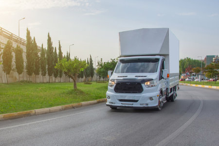 Modern delivery small shipment cargo courier frobt view van moving fast on motorway road turn city urban suburb. Busines distribution and logistics express serviceの写真素材