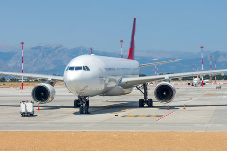Front view at airplane jet standing on parking, mobile ladders nearby, preparation for the upcoming flightの写真素材