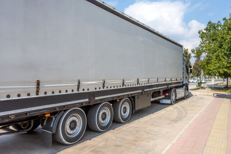 Truck trailer with gray awning trailer for cargo parked.