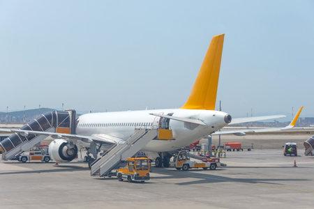 Jet airplane with a boarding steps at the airport apron crowd of people passengers board the planeの写真素材