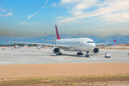 Front view at airplane jet standing on parking, mobile ladders nearby, preparation for the upcoming flightの写真素材