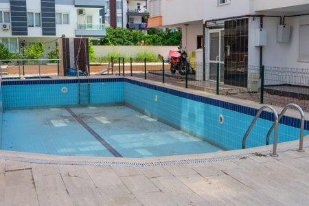 Empty swimming pool in the courtyard of a residential building, city.の写真素材