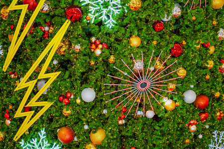 Texture background of branches of green decorated fragrant spruce toys, shiny balls, electric lights, garlands illumination zipper lightning symbol. New Year Christmas mood backgroundの写真素材