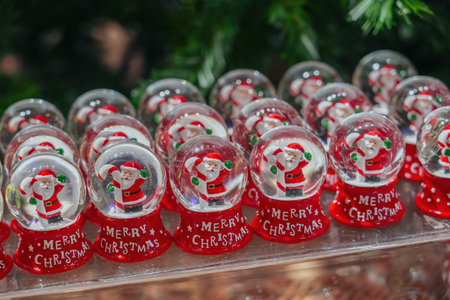 Lots of glass balls with Santa Claus and Christmas candy inside snow, fair, market.の写真素材