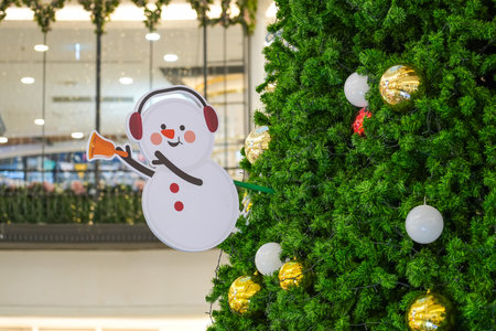 Snowman toy in ear warmers with a bell decoration on the New Year treeの写真素材