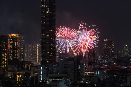 View of fireworks fireworks sparks explosions in the sky among tall buildings skyscrapers night cityの写真素材