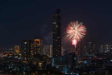 View of fireworks fireworks sparks explosions in the sky among tall buildings skyscrapers night cityの写真素材