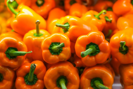 Orange pepper on the counter in a supermarket. A large number of bell peppers in a heap.の写真素材
