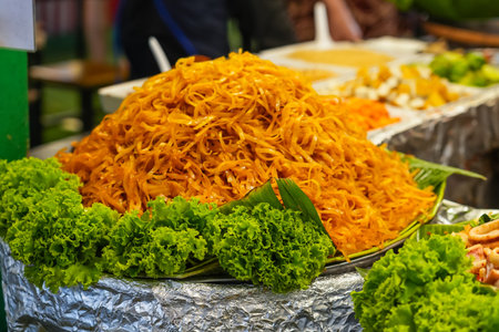 Cabbage noodles with fresh salad on a street market stallの写真素材