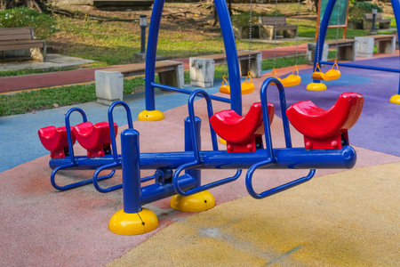 Blue red swing on a playground in a city parkの写真素材