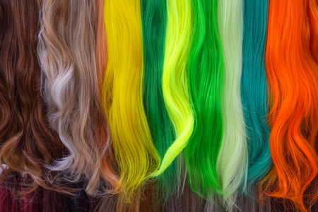 Hair samples of different colors palette. Different hair bright rich tint colors - yellow, green, crimson, orange. Various hair colors set background close up view. Extension equipment of naturalの写真素材