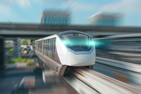 Modern high speed monorail train with bright headlights passes race station on the stage through a...