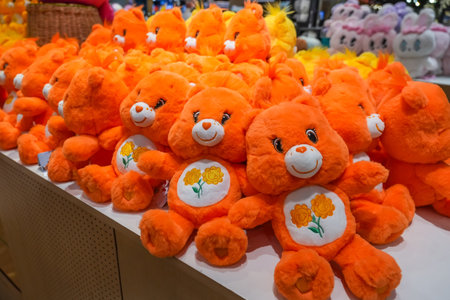 Teddy bears toys orange colored on a store shelf in a row.の写真素材