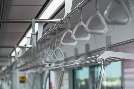 Individual handles on metal handrails inside the trainの写真素材