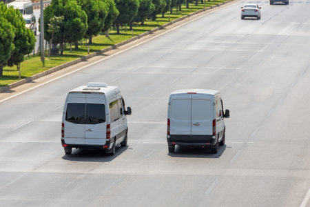 White modern delivery small shipment cargo courier van moving fast on motorway road to city urban...