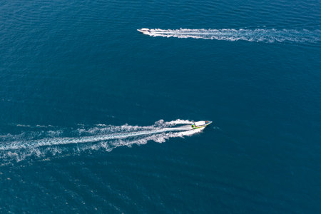 Two traffic flow of speedboats in the strait between tropical exotic islands, boats ply intensively carrying tourists. View from above top aerial.の写真素材