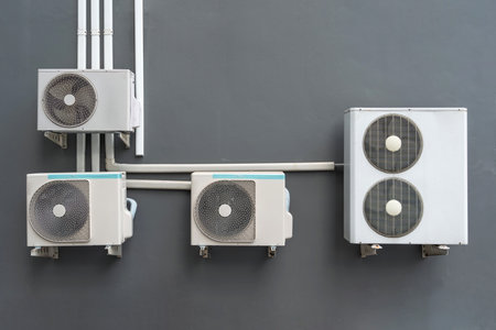 Air compressor, external split wall type of outdoor home air conditioner unit installed on outside building. Concepts of cool or heat or hot and air conditioning system maintenanceの写真素材