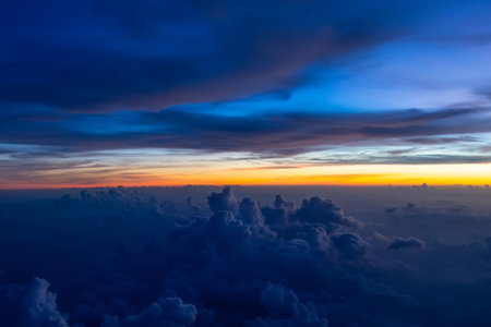 Dark heavy thunderstorm cumulus clouds in the morning at dawn, cloudscape view from an airplane.の写真素材