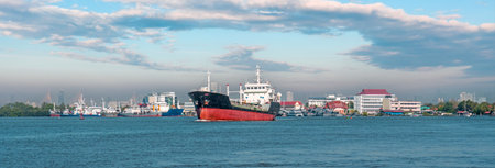 General cargo ship with cranes sailing in a still water. Freight transportation, nautical vessel,...