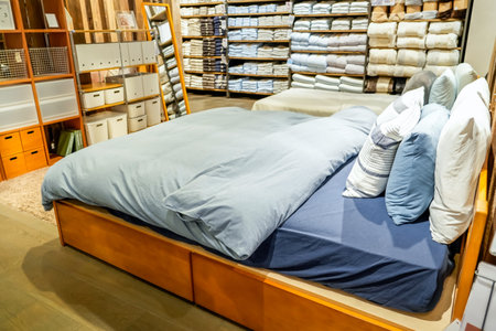 Double beds with glazed linens, duvet, sheets and pillows in furniture store.