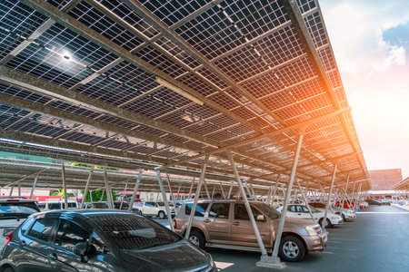 Solar panels installed over parking lot with parked cars for effective generation of clean energy in city.の写真素材