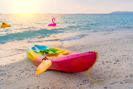 Kayak rowing boat for riding tourists people on a sandy picturesque tropical beach during sunset. in the water in the background.の写真素材