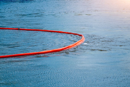 Floating barrier boom used to contain the release of debris river flow. Protection at a bridge construction site performing exercises to eliminate oil spills at sea.の写真素材
